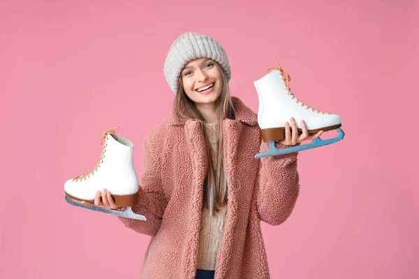 Beautiful young woman with ice skates on color background — Stock Photo, Image