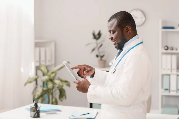 Homme afro-américain médecin avec tablette en clinique — Photo