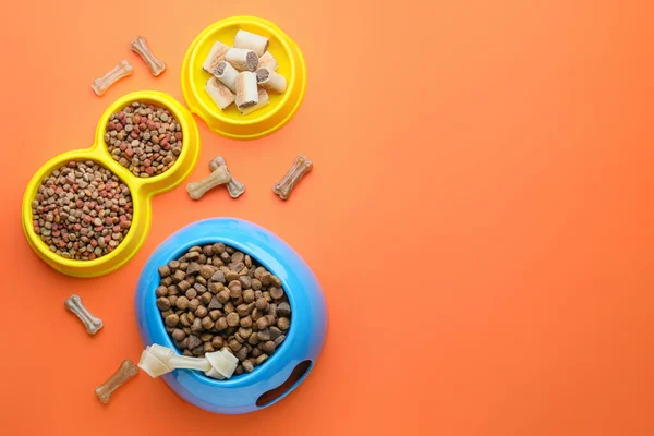 Bowls with dry pet food on color background — Stock Photo, Image