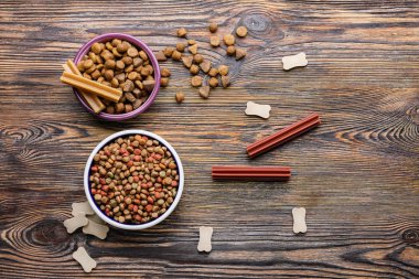 Tahta arka planda kuru hayvan mamasıyla dolu kaseler.