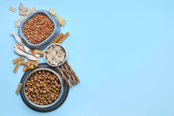 Bowls with dry pet food on color background — Stock Photo, Image