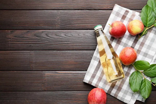Бутылка яблочного уксуса на деревянном фоне — стоковое фото