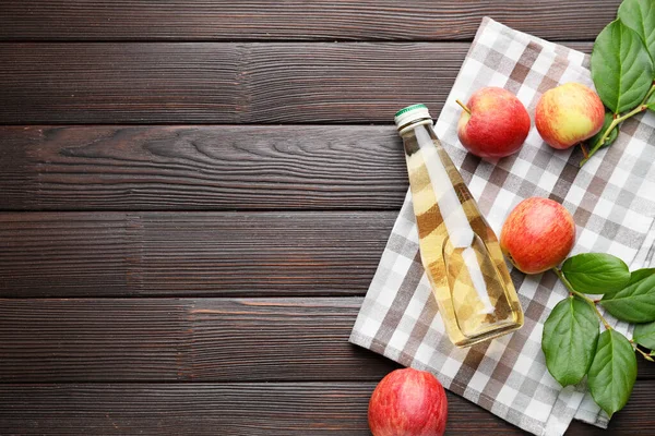 Botella de vinagre de manzana sobre fondo de madera — Foto de Stock