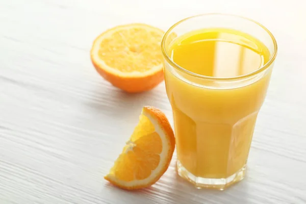 Ποτήρι φρέσκου χυμού πορτοκαλιού στο τραπέζι — Φωτογραφία Αρχείου
