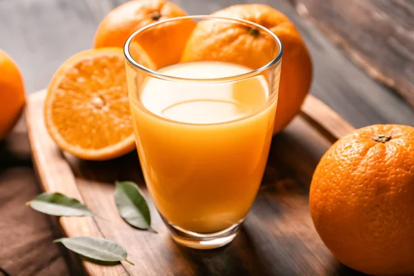 Ποτήρι φρέσκο χυμό πορτοκαλιού, σε φόντο ξύλινη — Φωτογραφία Αρχείου