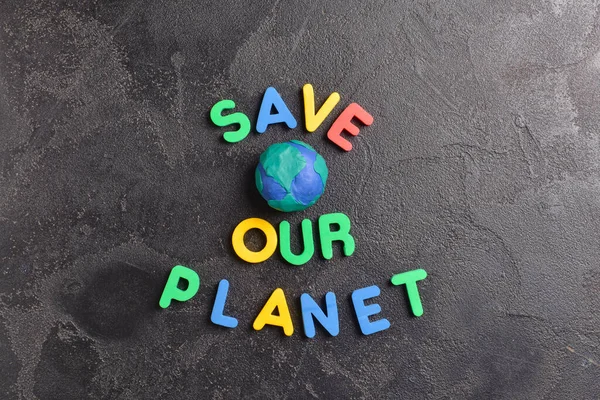 Composition with text SAVE OUR PLANET on dark background. Earth Day celebration — Stock Photo, Image