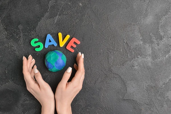 Female hands, planet and word SAVE on dark background. Earth Day celebration — Stock Photo, Image