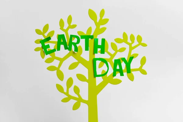 Figure of tree with text  EARTH DAY on light background — Stock Photo, Image