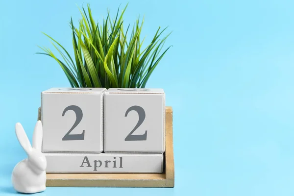 Calendar with date of Earth Day and plant on color background — Stock Photo, Image