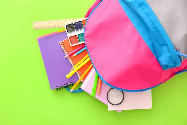 Mochila escolar con papelería sobre fondo de color —  Fotos de Stock