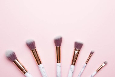 Renk arkaplanındaki makyaj fırçaları