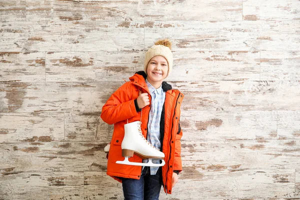 Petit garçon mignon avec patins à glace sur fond en bois — Photo