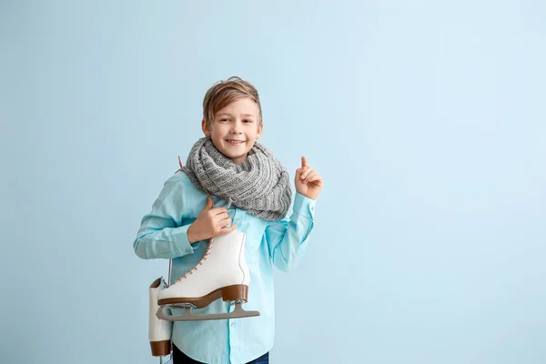 Petit garçon mignon avec patins à glace sur fond de couleur — Photo