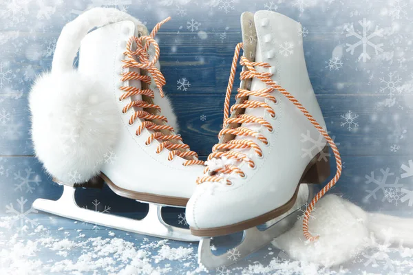 Ice skates and snow on color wooden background — Stock Photo, Image