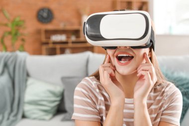 Evde VR gözlüklü genç bir kadın.