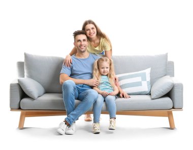 Happy young family with sofa on white background