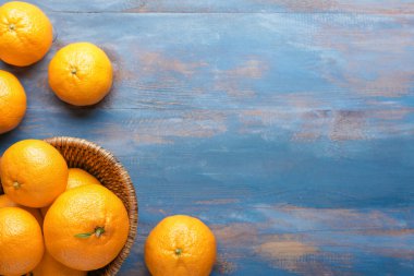 Basket with sweet tangerines on wooden background