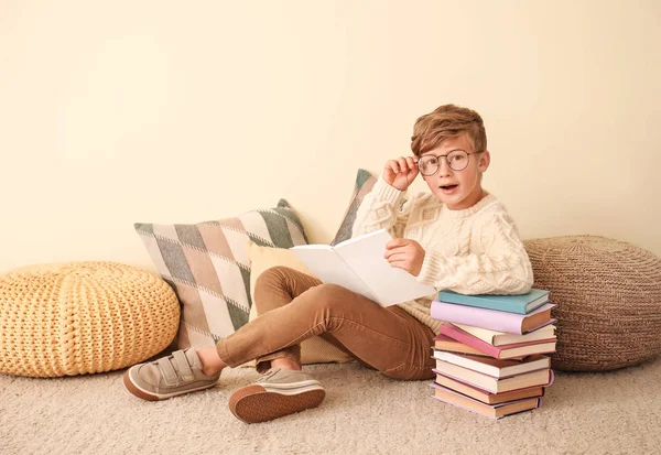 Kleiner Junge liest Bücher in der Nähe der Wand — Stockfoto