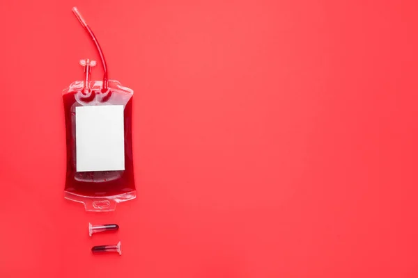 Blood pack for transfusion and test tubes on color background — Stockfoto