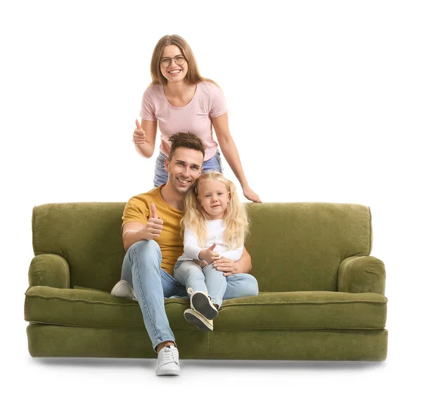 Счастливая молодая семья с диваном, показывающим большой жест вверх на белом фоне — стоковое фото
