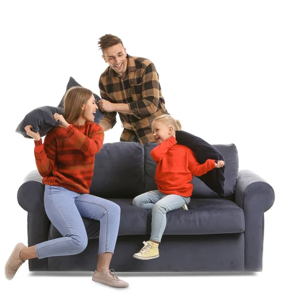 Feliz jovem família lutando com travesseiros no sofá contra fundo branco — Fotografia de Stock