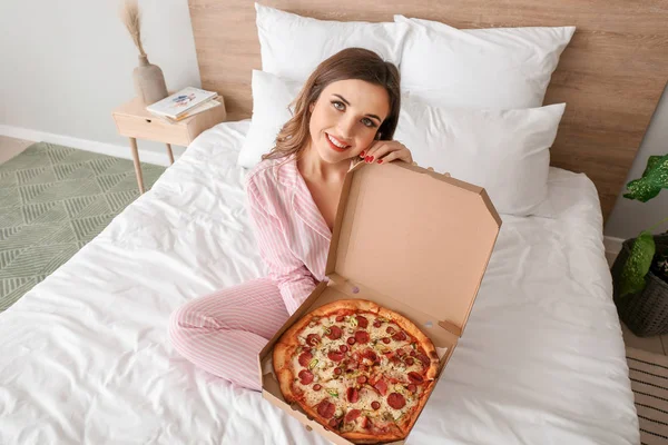 Ранок красивої молодої жінки зі смачною піцою в спальні — стокове фото