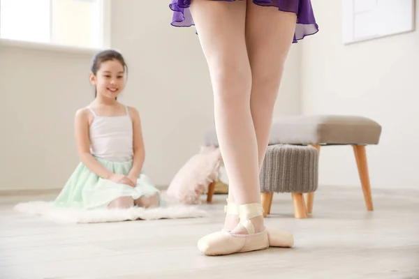 Little ballerina looking at coach at home — Stock Photo, Image