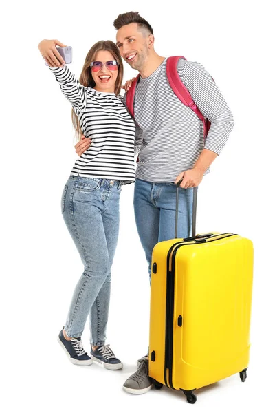 Pareja de turistas con equipaje tomando selfie sobre fondo blanco — Foto de Stock