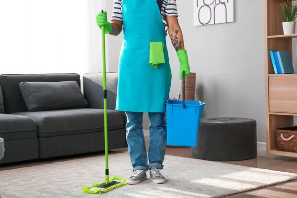Jovem homem asiático com suprimentos de limpeza em casa — Fotografia de Stock