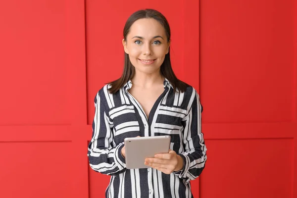 Mujer joven con Tablet PC sobre fondo de color — Foto de Stock