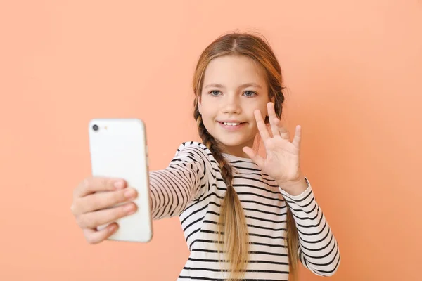 Söt liten flicka som tar selfie på färg bakgrund — Stockfoto