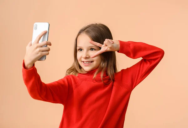 Linda niña tomando selfie en el fondo de color — Foto de Stock