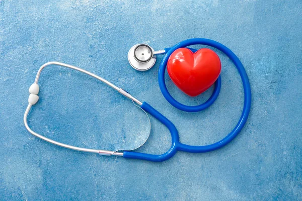 Stethoscope and heart on color background. Cardiology concept — 스톡 사진