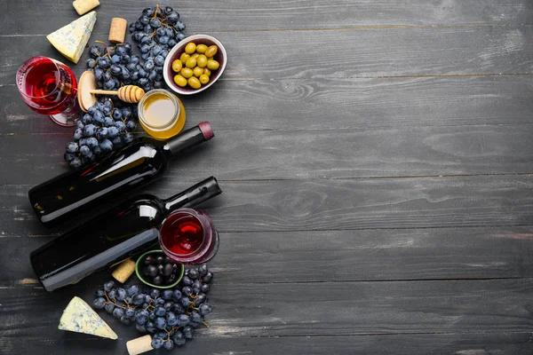 Delicious wine with snacks on dark wooden background — Stock Photo, Image