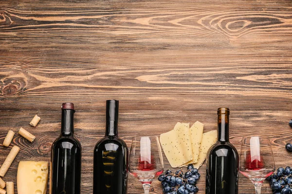 Köstlicher Wein mit Käse auf Holzgrund — Stockfoto