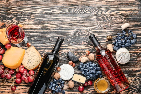 Köstlicher Wein mit Snacks auf Holzgrund — Stockfoto