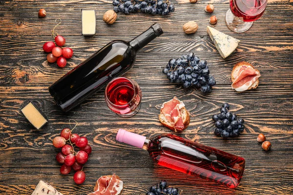 Delicioso vinho com lanches em fundo de madeira — Fotografia de Stock