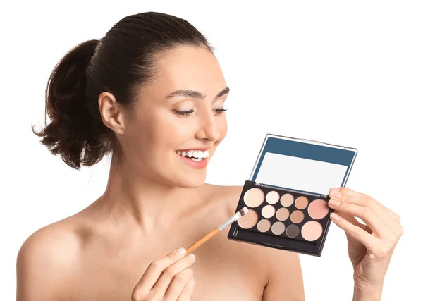 Vacker ung kvinna tillämpa makeup på vit bakgrund — Stockfoto