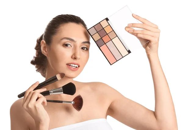 Vacker ung kvinna tillämpa makeup på vit bakgrund — Stockfoto