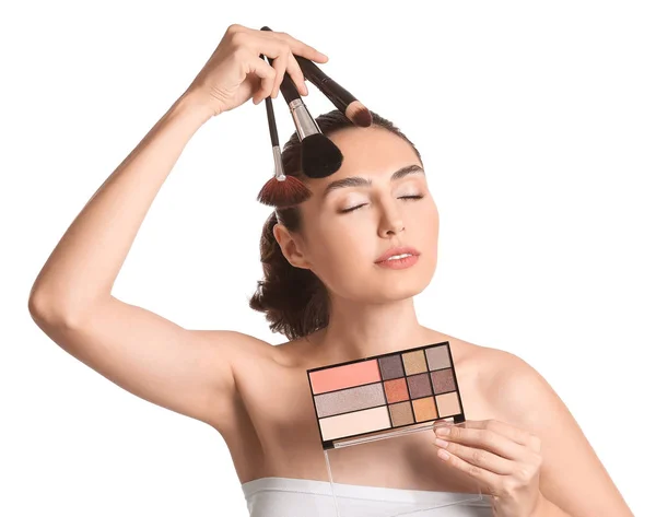 Vacker ung kvinna tillämpa makeup på vit bakgrund — Stockfoto
