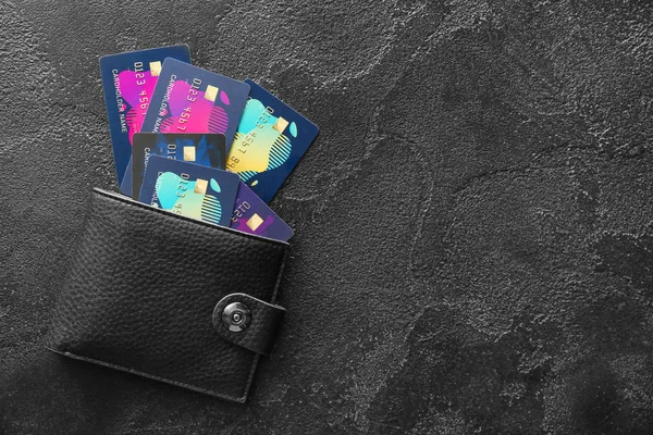 Cartera con diferentes tarjetas de crédito sobre fondo oscuro — Foto de Stock