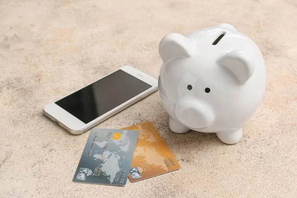Credit cards with piggy bank and mobile phone on grey background. Concept of online banking — 스톡 사진