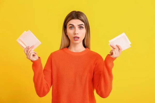 Jeune femme avec des serviettes menstruelles sur fond de couleur — Photo