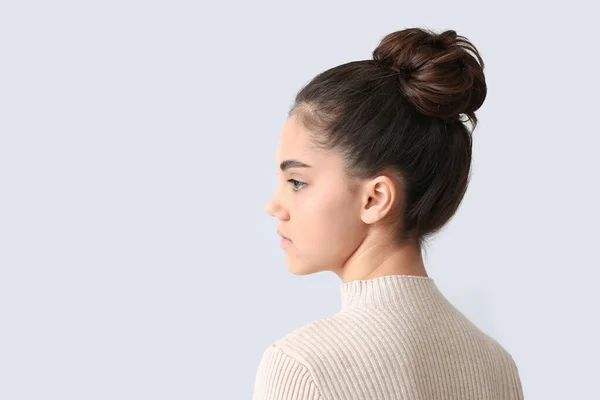 Ung kvinna med vacker frisyr på ljus bakgrund — Stockfoto