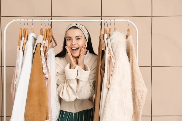 Estilista feminina perto de rack com roupas modernas — Fotografia de Stock