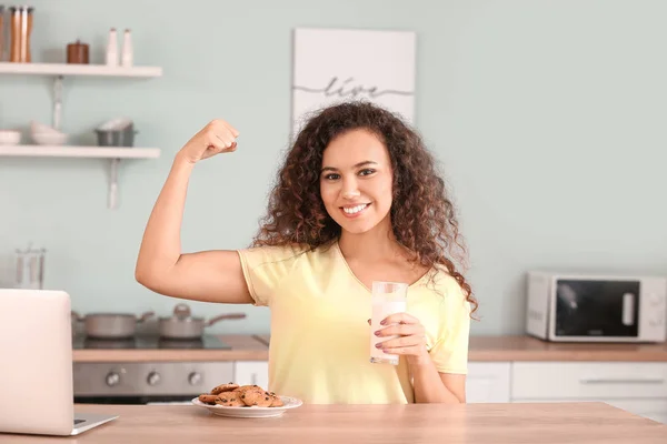 Young African-American woman with milk in kitchen — Stock Photo, Image