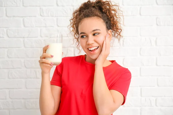 Junge afroamerikanische Frau mit Milch auf weißem Hintergrund — Stockfoto