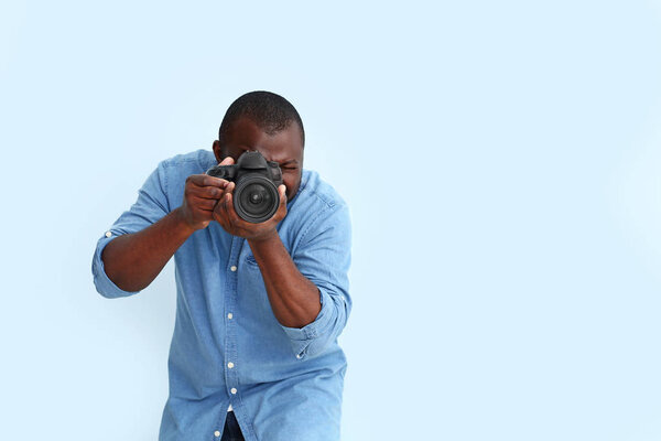African-American photographer on color background