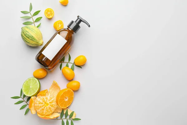Cosmetic product in bottle and citrus fruits on white background — Stock Photo, Image