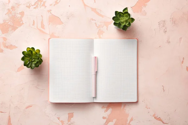 Ноутбук с ручкой и растениями на белом фоне — стоковое фото